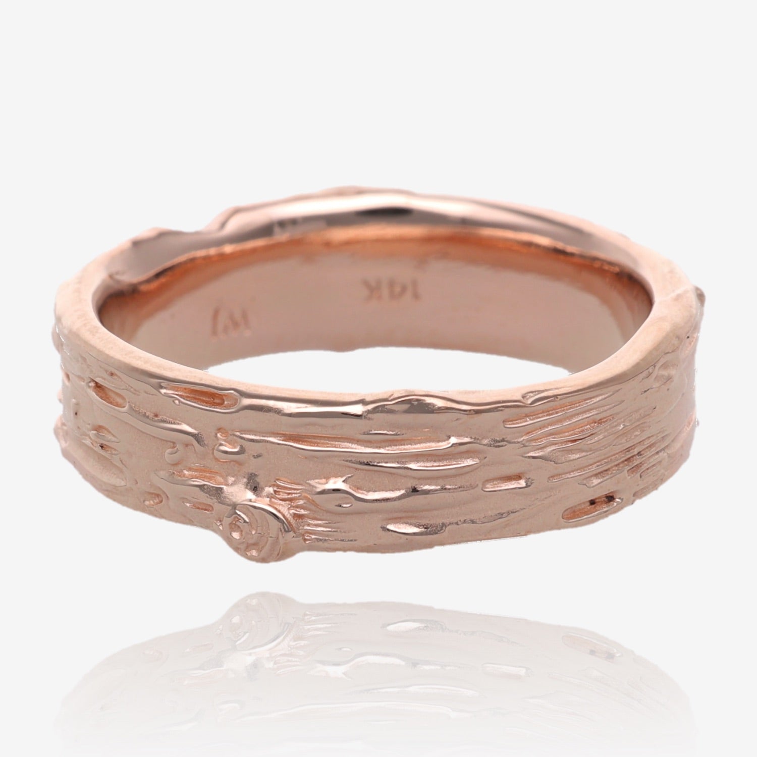Image shows pink gold band 6mm wide, with raised and recessed lines resembling birch bark. Texture includes knots and divots and slight rough areas. 14k stamp and makers mark also visible