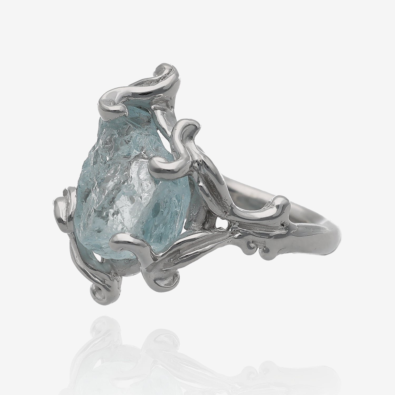 Side view of raw aquamarine crystal set in silver prong setting