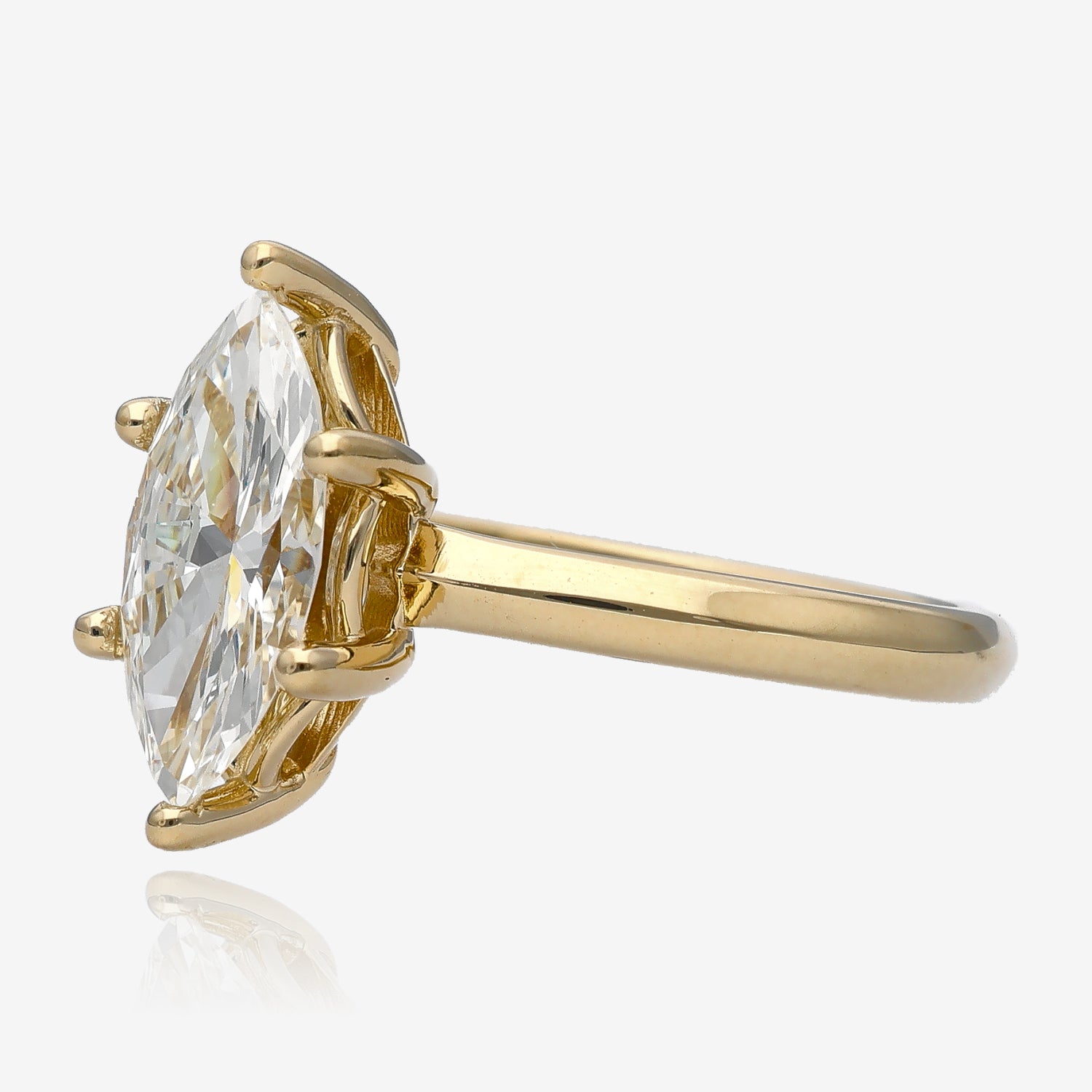 Side view of large diamond cut in a marquise shape. It is set in a yellow gold solitaire with small arches between prongs