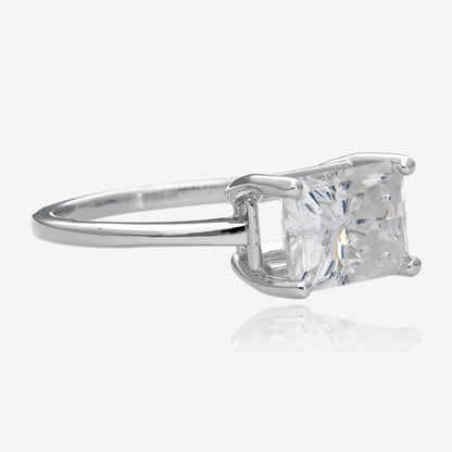 Angled view of radiant rectangular cut white moissanite set east west in a simple slender white gold ring with four prongs