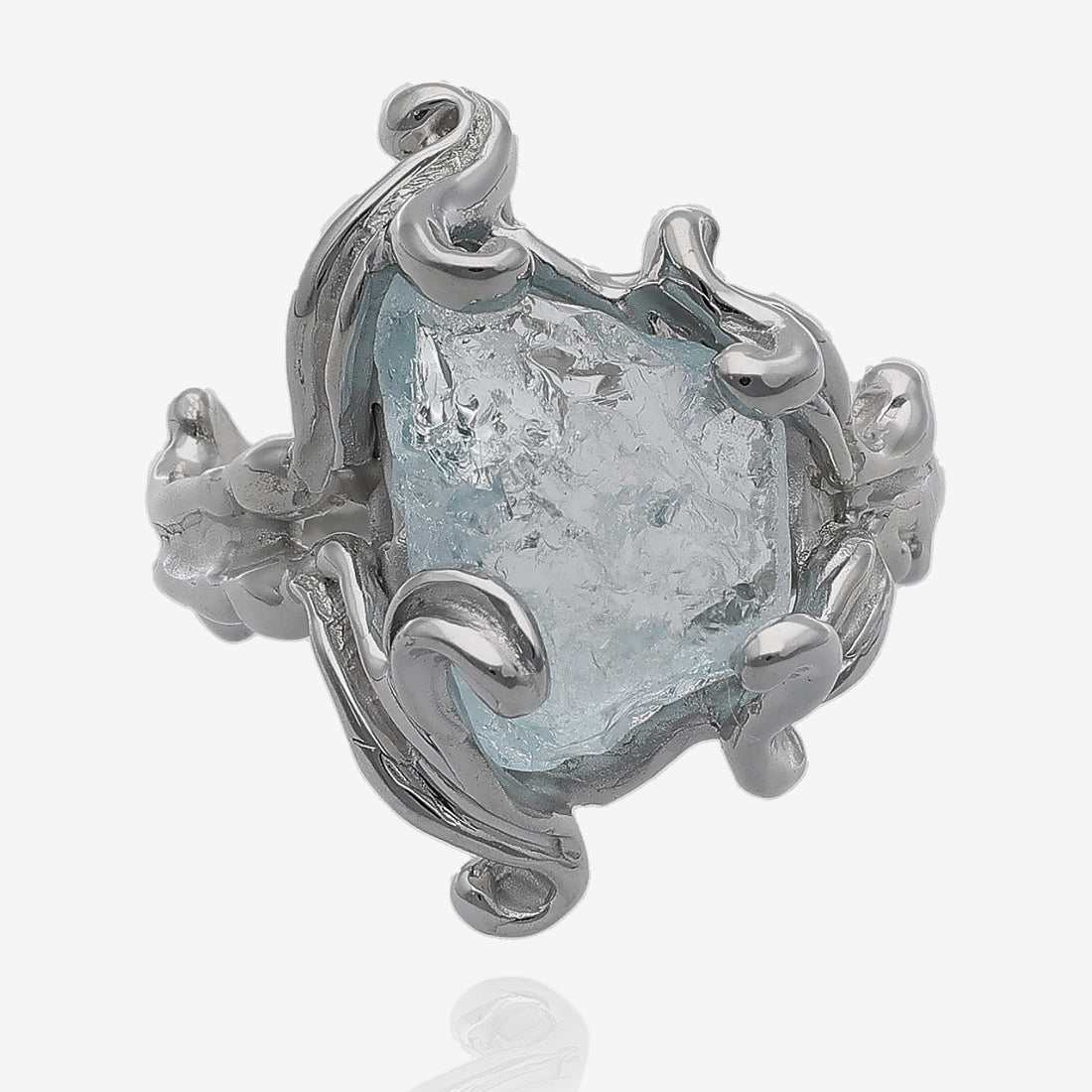 Rough aquamarine gem in silver ring framed in curls